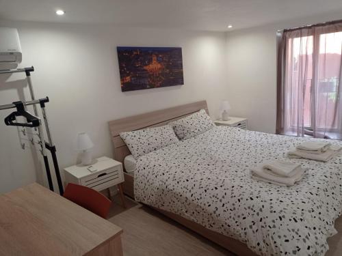 een slaapkamer met een zwart-wit bed en een tafel bij Bilocale in centro storico -Le mensaline- Casa Chiricopo in Modica