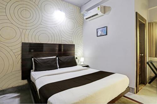 a bedroom with a bed and a wall at Super Collection O Hotel Bhinna Sakala in Bhubaneshwar