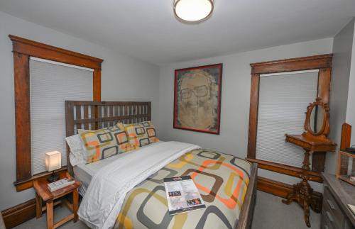 a bedroom with a bed and two windows at Berrodin Bed & Breakfast in Akron