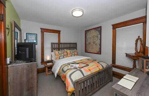 a bedroom with a bed and a flat screen tv at Berrodin Bed & Breakfast in Akron