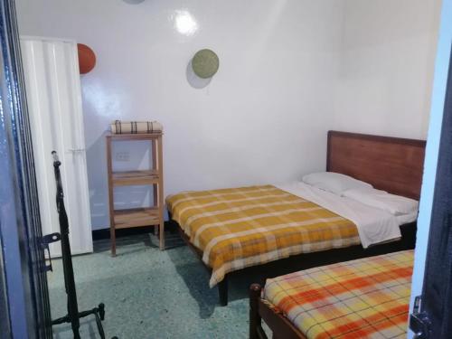 a bedroom with two beds and a night stand at Casa La Plazuela in Curití