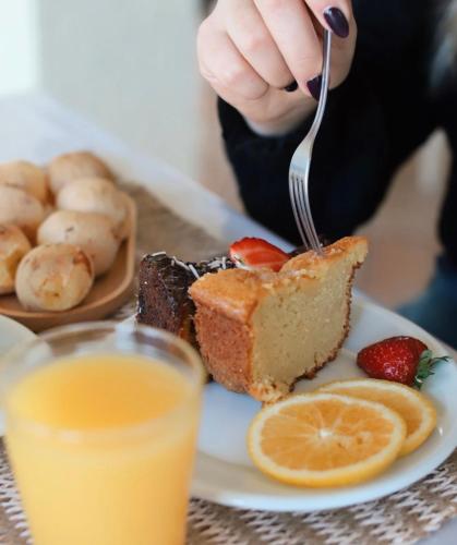 a person eating a piece of cake with a fork at Gaivotas Praia Hotel in Florianópolis