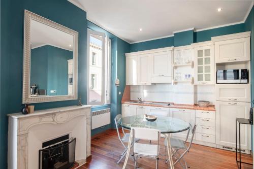 une cuisine avec une table en verre et une cheminée dans l'établissement Cannes Luxury Rental - Cosy apartment to rent 50m from the beaches, à Cannes