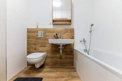 een badkamer met een toilet, een wastafel en een bad bij Apartmán Troika in Liptovský Hrádok