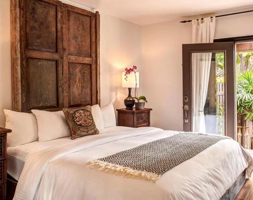 a bedroom with a large white bed and a window at Talavera Palm Springs in Palm Springs