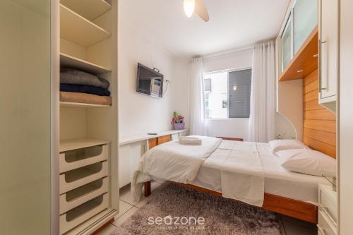 um pequeno quarto com uma cama e uma janela em Apto aconchegante no centrinho dos Ingleses LIB203 em Florianópolis