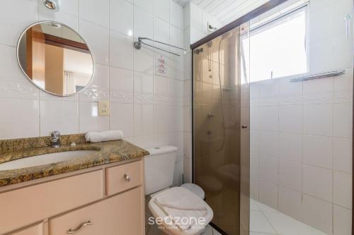 uma casa de banho com um chuveiro, um lavatório e um WC. em Apto aconchegante no centrinho dos Ingleses LIB203 em Florianópolis