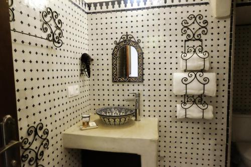 a bathroom with a sink and a mirror at Riad Alassala Fes in Fès