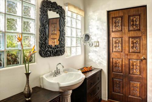 a bathroom with a sink and a mirror and a door at Talavera Palm Springs in Palm Springs