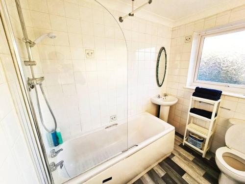 a bathroom with a tub and a toilet at Whitefield, Manchester in Manchester