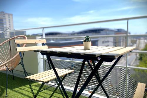 un tavolo e sedie su un balcone con una pianta di Le Sunset-Cosy appart avec parking et balcon a Le Havre