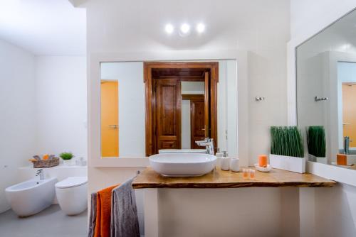 uma casa de banho branca com um lavatório e um espelho em Casa Frangiò Modern Apartment Historical Centre em Nápoles