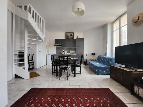 sala de estar con mesa y sofá azul en Appartement a deux pas de la Promenade des Anglais, en Niza
