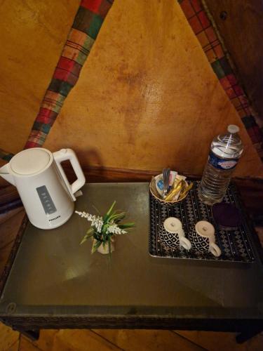 a table with a coffee maker and a drink on it at Dôme en bord de rivière in Saint-Claude