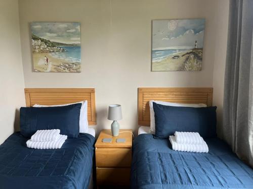 a bedroom with two beds with blue sheets at Idyllic Entire Chalet in Bideford Bay holiday Park near Clovelly in Bideford