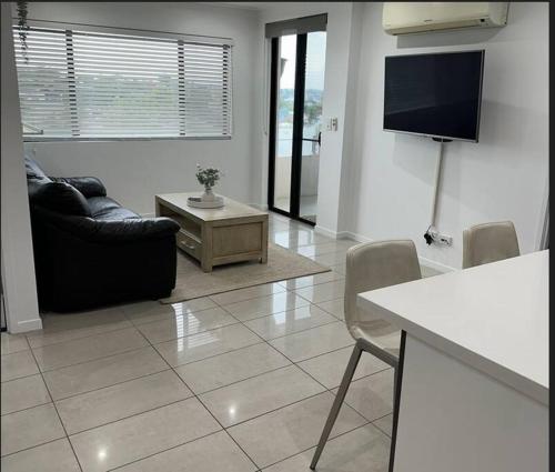 salon z kanapą i telewizorem w obiekcie New Farm 2 Bed 2 Bath 1 Car space perfect location w mieście Brisbane