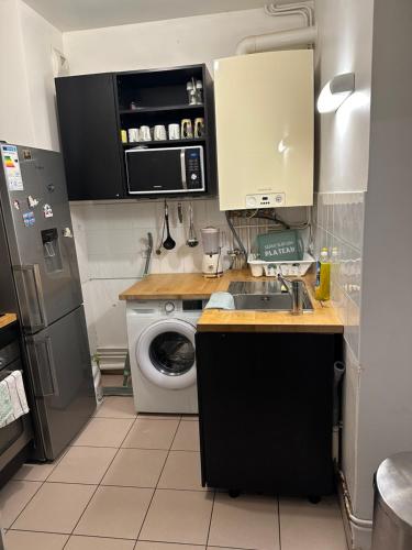 a kitchen with a sink and a washing machine at Appartement meublé à Croissy sur Seine in Croissy-sur-Seine