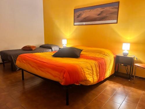 una camera da letto con un grande letto con una coperta arancione di Vespucci 23 ad Alessandria