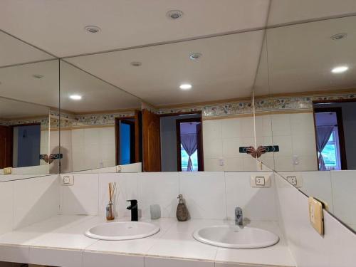 baño con 2 lavabos y espejo grande en Casa del Valle en Ushuaia