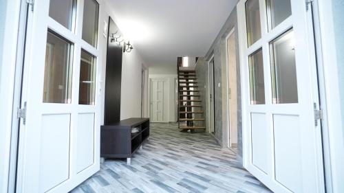 a hallway with two white doors and a room with shelves at Casa de pe rau in Telega