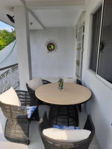VILLA MARIA في Turbaco: طاولة صغيرة وكراسي على شرفة