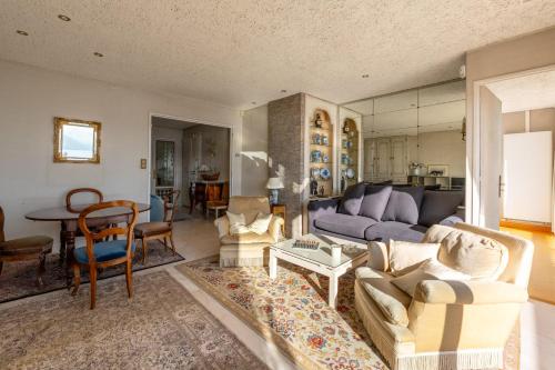 un salon avec un canapé et une table dans l'établissement Le Panoramic - Magnifique Vue sur le lac d'Annecy, à Annecy