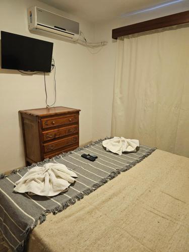 a bedroom with a bed with a dresser and a tv at Ribera Sur Hotel - Los Algarrobos - Tanti in Tanti