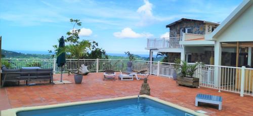 a patio with a swimming pool and a house at VILLA ELEM in Rivière-Pilote