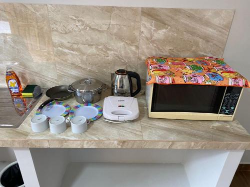 a counter top with a microwave and cups on it at Apartamentos IVAGO in Encarnación