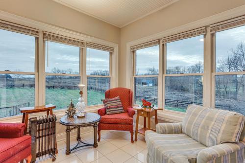 a living room with two chairs and a table and windows at Shelbyville Home - On to the Bourbon Trail! in Shelbyville