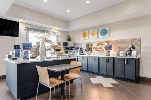 a kitchen with a counter with chairs and a table at Best Western Auburndale Inn & Suites in Auburndale