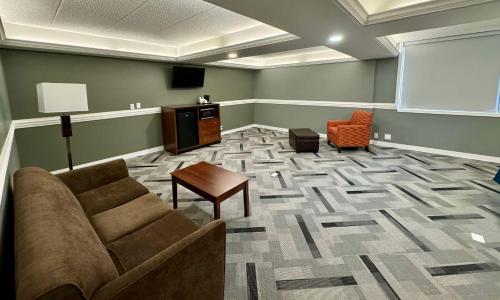 a waiting room with a couch and a table and a screen at Best Western Executive Inn Kenosha - Pleasant Prairie in Kenosha