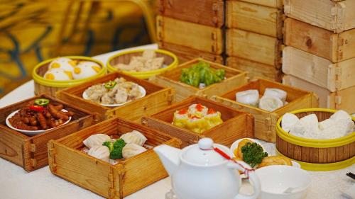 a table topped with wooden boxes filled with different types of food at Junluxe Hotel Guangzhou Zengcheng-Free Shuttle Bus For Canton Fair in Zengcheng
