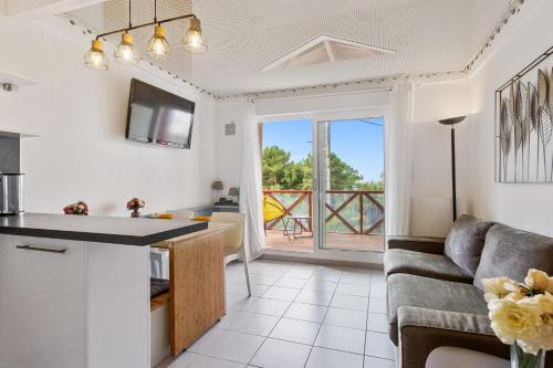 cocina y sala de estar con sofá y mesa en Cosy duplex apartment with ocean view in Biarritz - Welkeys, en Biarritz