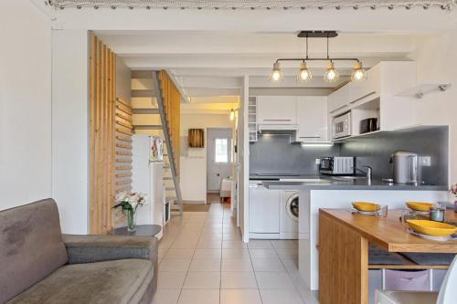比亞里茨的住宿－Cosy duplex apartment with ocean view in Biarritz - Welkeys，厨房以及带沙发和桌子的客厅。