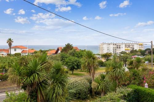 - une vue sur une ville avec des palmiers et un bâtiment dans l'établissement Duplex Milady - Welkeys, à Biarritz