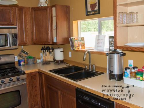 a kitchen with a sink and a stove top oven at A Hyde Away Inn B&B in Tok