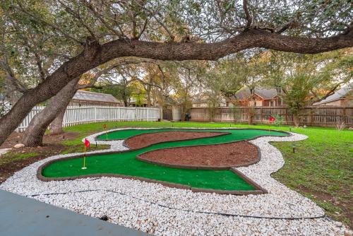a golf course with a tree and a green at Beautiful Texas Ranch House, Game Room & Minigolf in San Antonio