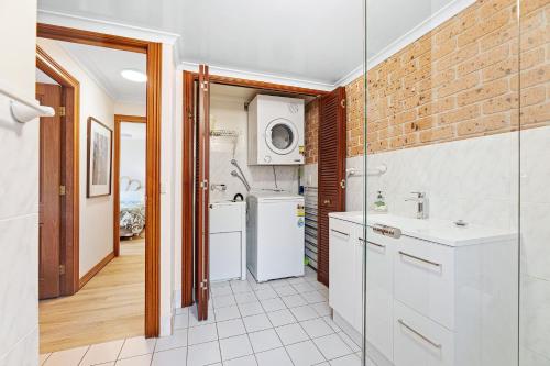 a kitchen with white appliances and a brick wall at Grand Pacific 1 Unit 1 - Ground Floor in Narooma