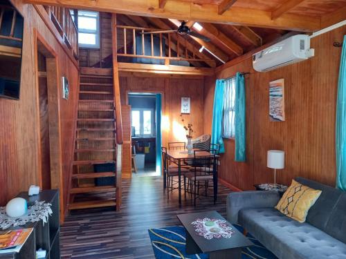uma sala de estar com um sofá e uma escada em espiral em Mx2 Cottage em Calibishie