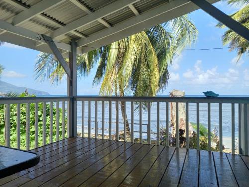 eine Terrasse mit Meerblick in der Unterkunft Mx2 Cottage in Calibishie