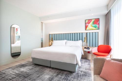 a hotel room with a bed and a chair at Holiday Inn & Suites Geelong by IHG in Geelong