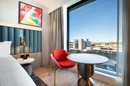 a hotel room with a bed and a table and a window at Holiday Inn & Suites Geelong by IHG in Geelong