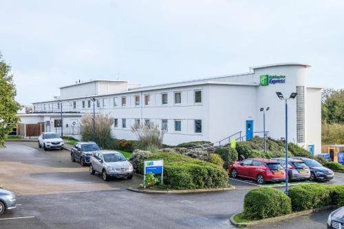 a large white building with cars parked in a parking lot at Holiday Inn Express Ramsgate – Minster by IHG in Ramsgate