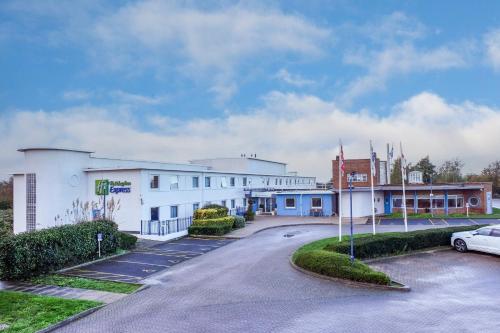 a building with a car parked in a parking lot at Holiday Inn Express Ramsgate – Minster by IHG in Ramsgate