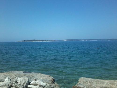 a large body of water with rocks in the foreground at Guesthouse Adria in Pula