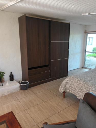 1 dormitorio con 1 cama y armario grande en Posada Mahatma en Tacuarembó