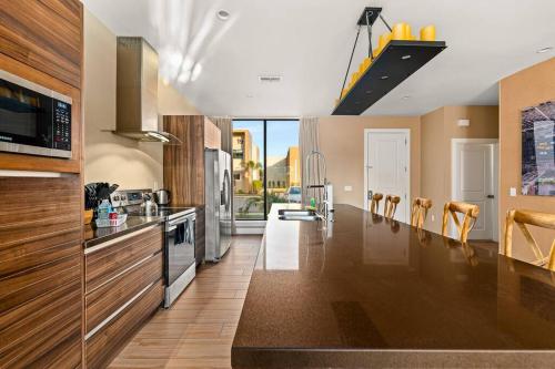 a large kitchen with wooden cabinets and a counter top at Outdoor Kitchen + 8 Min to Disney + Resort Cabanas in Orlando