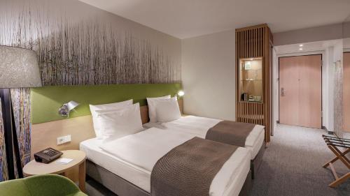 a hotel room with a bed and a chair at Holiday Inn Frankfurt - Alte Oper by IHG in Frankfurt/Main