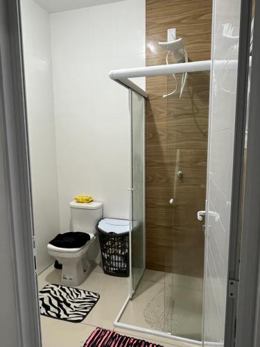 a bathroom with a toilet and a glass shower at Casa com piscina em Imbé/Rs in Imbé